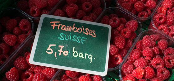 Framboises emballées sur un étal de marché suisse